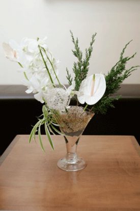 סידור פרחים בכלי מעוצב מסחלבים ואנטוריום לבנים
